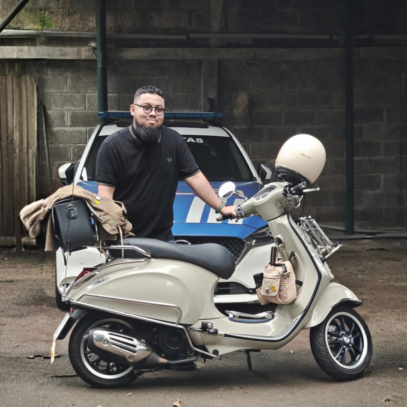 Tegar standing beside a white classic scooter.
